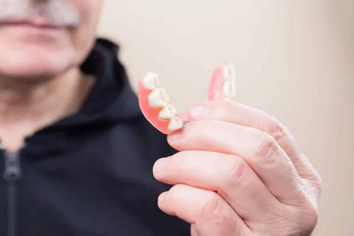 man holding dentures