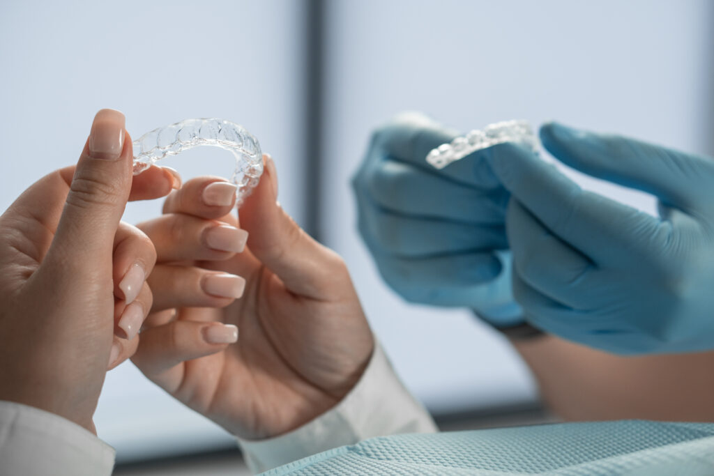Patient holding clear aligners during an Invisalign consultation at Dental Care of Oak Park